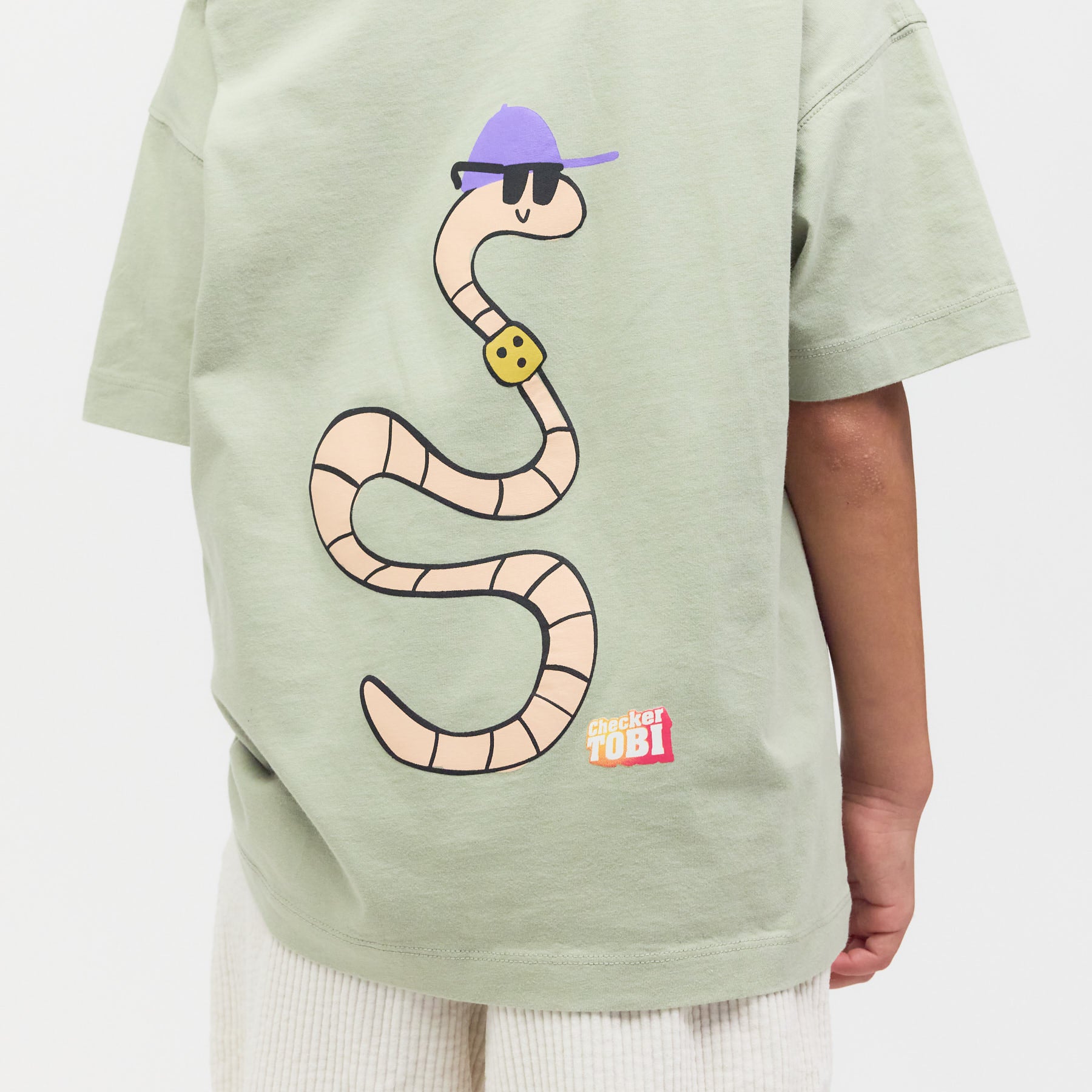 Rückseite des salbeigrünen Shirts am Model: Großer Regenwurm-Print auf robustem Bio-Stoff für langlebigen Tragespaß.